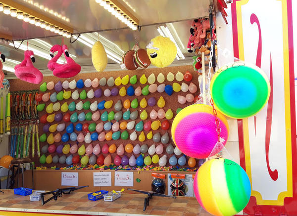 An einem Schießstand kann auf bunte Luftballon gezielt werden.