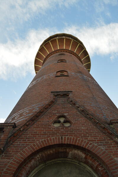 Blick von unten auf den Wasserturm mit Sicht auf die kunstvoll verlegten Ziegel des Einganges.