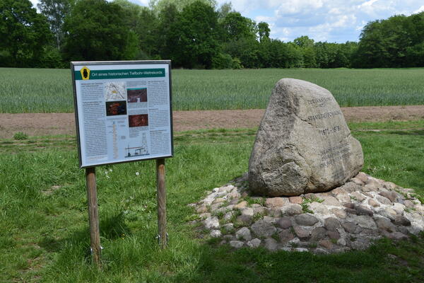 Ein großer Stein und eine Hinweistafel in der Liether Kalkgrube weisen auf den Ort eines historischen Tiefbohr Weltrekords hin.