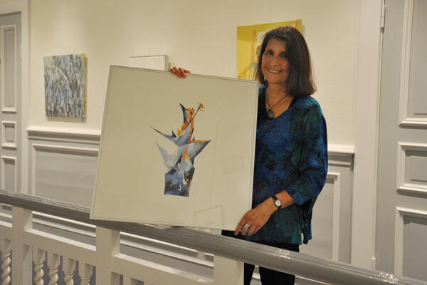 Susanne Berger hält in der Galerie der Weißen Villa eins ihrer Bilder in den Händen.