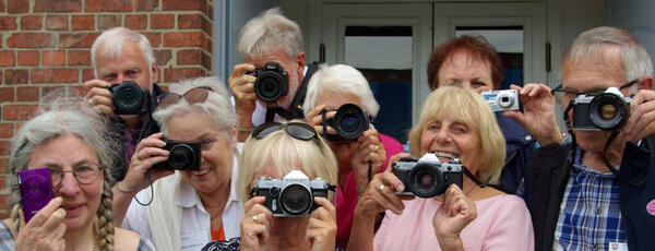 Symbolbild. Mehrere Mitglieder ders Seniorenrates posieren mit ihren Kameras.