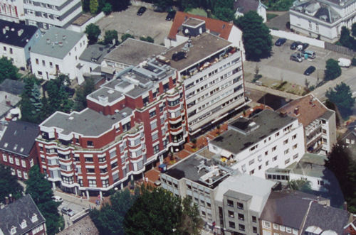 Bild vergr&ouml;&szlig;ern: Drohnenansicht des roten Flora Gesundheits-Zentrums in Elmshorn, umgeben mit den Nachbargeb&auml;uden.