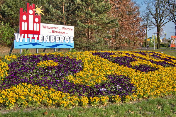 Der Ortseingang von Wittenberge mit einem Schild. Mit verschiedenfarbigen Blumen wurde das Wort Wittenberge geschrieben.