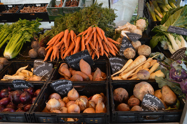 Marktstand mit Gemüse aus der Region: Karotten, Zwiebeln, Rettich und Rüben.