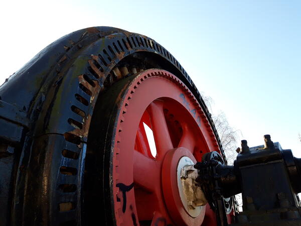 Ein großes, rotes Rad mit Mechanik.