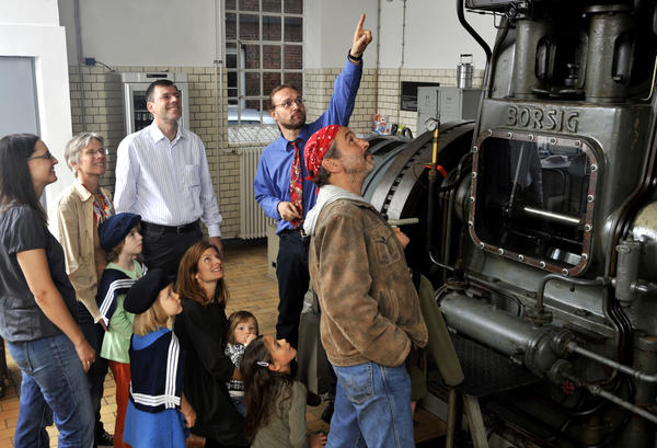 Ein Mitarbeiter des Industriemuseums erklärt bei einer Museumsführung den staunenden kleinen und großen Gästen die alte Dampfmaschine.