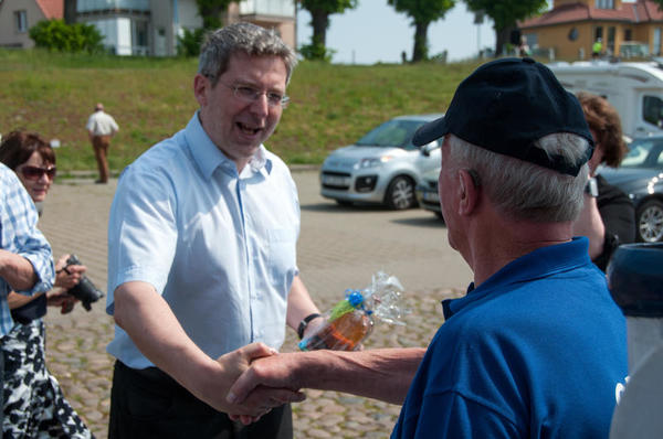 Bürgermeister Dr. Oliver Hermann begüßt Kapitän Günther Holtz mit einer Flache Fährmann.