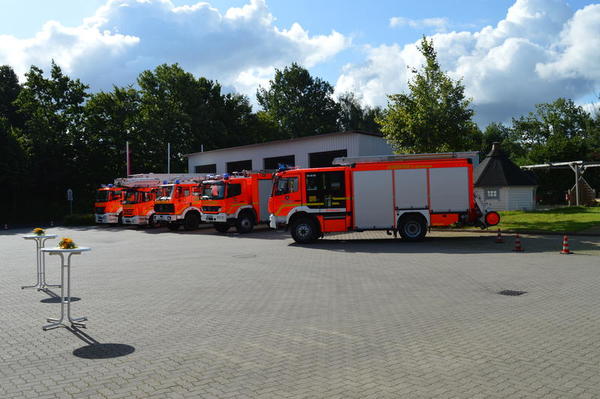 Die roten Einsatzwagen der Feuerwehr stehen in einer Reihe auf dem Vorplatz.
