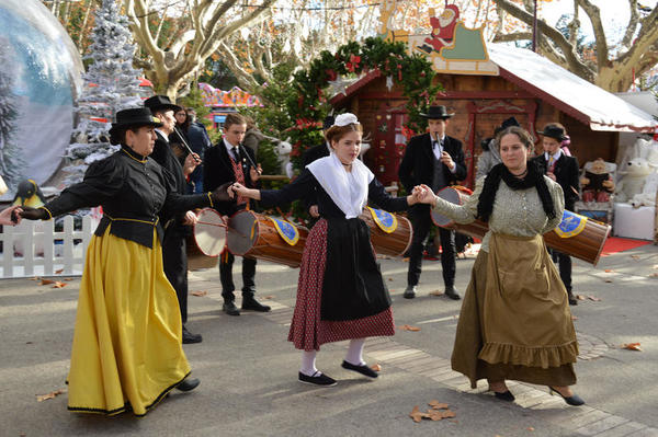 Auf dem Weihnachtsmarkt der Partnerstadt in Frankreichtanzt eine Gruppe von Frauen in traditionellen Trachten.