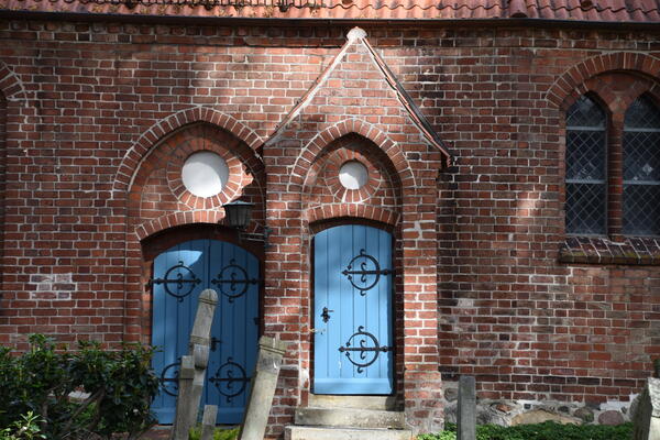 Eine blaue Holztür in der historischen Kirche.