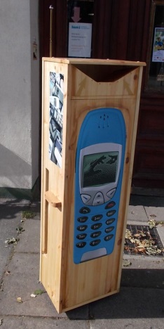 Gro&szlig;e Sammelbox aus Holz mit einem ebenso gro&szlig;en Bild eines alten Handys.