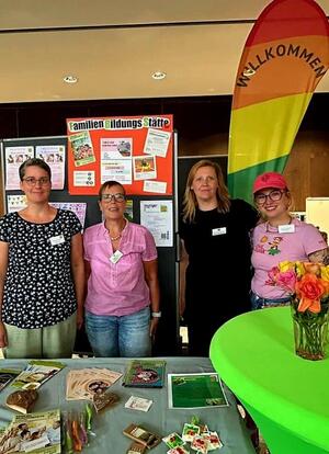 Bild vergr&ouml;&szlig;ern: Das Foto zeigt vier Frauen an einem Stand der Baby-Begr&uuml;&szlig;ung im Kollegiumssaal. Im Hintergrund sind Schautafeln und eine Beachflag zu sehen.