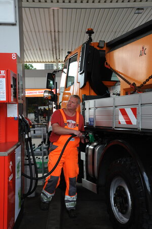Bild vergr&ouml;&szlig;ern: Ein Mann im orangenen Overall tankt einen Unimog der Stadt Elmshorn an der Tankstelle.