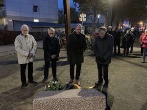 Bild vergr&ouml;&szlig;ern: Vier M&auml;nner - darunter der stellvertretende B&uuml;rgervorsteher Thorsten Mann-Raudies sowie B&uuml;rgervorsteher Andreas Hahn - stehen am Gedenkstein an der ehemaligen Synagoge am Flamweg, um den Orn der Reichpogromnacht zu gedenken.