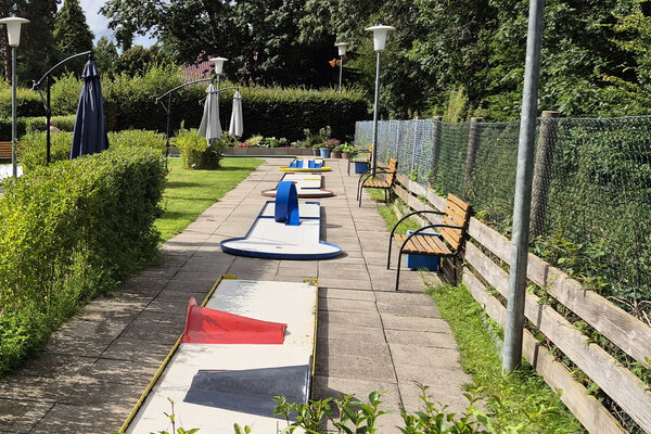Bild vergr&ouml;&szlig;ern: Vier Bahnen der Minigolf-Turnieranlage Kaltenweide mit gepflegten Gr&uuml;nfl&auml;chen und Sitzb&auml;nken.