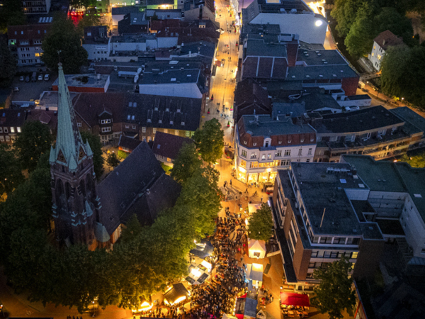 Auf dem Bild ist eine Luftbildansicht der abendlich beleuchteten Elmshorner Innenstadt zu sehen