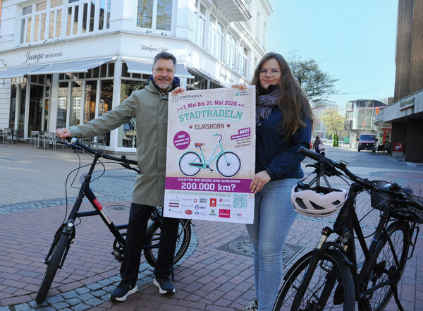 Bild vergr&ouml;&szlig;ern: Ein Mann und eine Frau stehen mit Fahrr&auml;dern und einem STADTRADELN-Plakat in der Fu&szlig;g&auml;ngerzone.