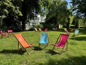 Bild vergr&ouml;&szlig;ern: Mehrere bunte Liegest&uuml;hle auf einer Wiese im Gr&uuml;nen.