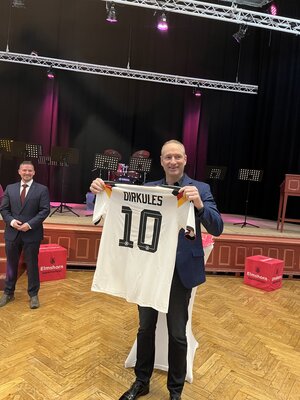 Bild vergr&ouml;&szlig;ern: Der scheidende Erste Stadtrat Dirk Moritz mit einem Fu&szlig;ball-WM-Trikot der deutschen Nationalmannschaft, auf dessen R&uuml;ckseite die Nummer 10 und der Name Dirkules steht.