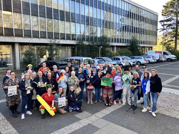 Bild vergr&ouml;&szlig;ern: Vertreterinnen und Vertreter von Vereinen und Organisationen werben auf dem Rathausvorplatz f&uuml;r die Kultur- und Ehrenamtsmesse. Im Hintergrund sind Fahrzeuge und das Rathaus zu erkennen.
