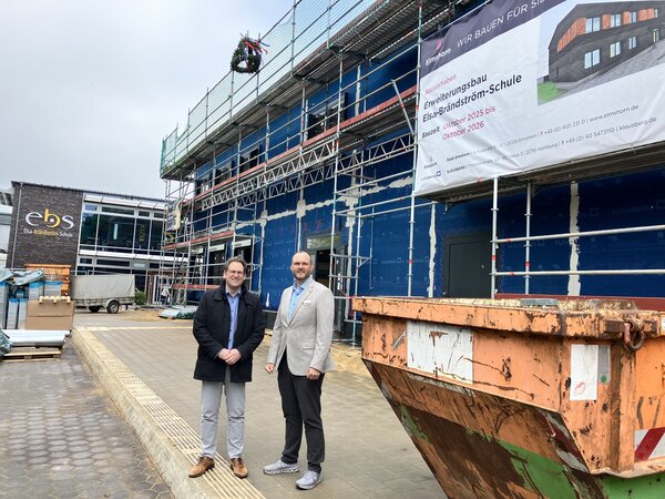 Bild vergr&ouml;&szlig;ern: &Uuml;ber die rasanten Fortschritte auf der Baustelle freuen sich Schulleiter Kevin Amberg (links) und Erster Stadtrat Michael Leeske beim Richtfest.
