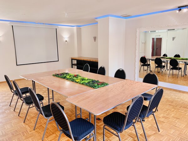 Bild vergr&ouml;&szlig;ern: Innenansicht eines Seminarraums mit einer Tischtafel und zehn St&uuml;hlen vor einem an der Wand befestigten Whiteboard.
