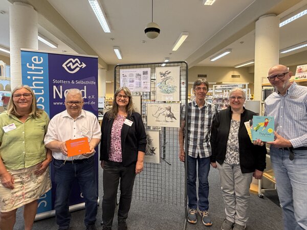 Frauen und M&auml;nner in einem Raum der Stadtb&uuml;cherei Elmshorn, in dem eine Ausstellung des K&uuml;nstlers Carsten Martin zu sehen ist.