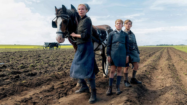 Szene aus Fatih Akins Kino-Film "Amrum" - Frau mit zwei Kindern und einem Pferd auf einem Acker.