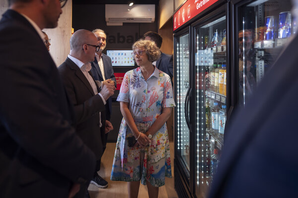 Bild vergr&ouml;&szlig;ern: Personen in einem Smart Shop. Rechts sind K&uuml;hlbereiche mit Warenauslage zu sehen.