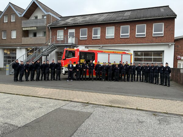 Feuerwehrleute mit neuem L&ouml;schfahrzeug vor der Feuerwache Nord in  der Elmshorner Kirchenstra&szlig;e.