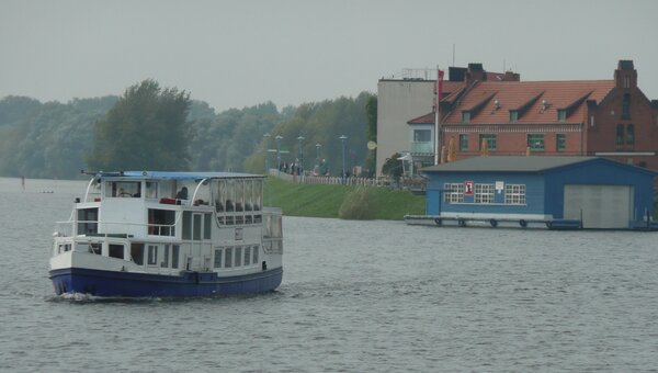 Bild vergr&ouml;&szlig;ern: Ein Ausflugsschiff auf der Elbe, im Hintergrund die Stadt Wittenberge.