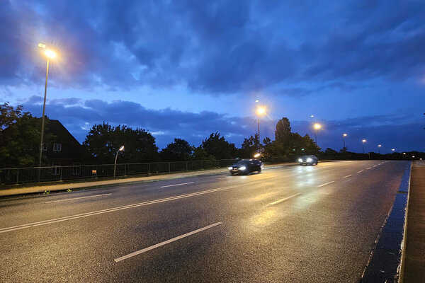 Bild vergr&ouml;&szlig;ern: Zu sehen ist ein Teil der Ost-West-Br&uuml;ckein Elmshorn, auf der zwei Pkw fahren, und die durch die Stra&szlig;enlaternen beleuchtet wird.