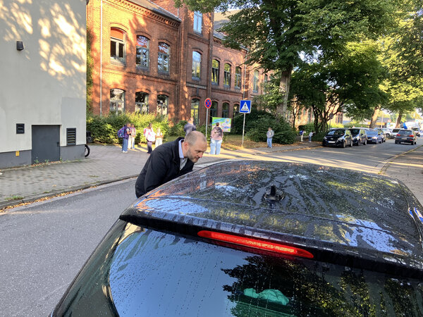Bild vergr&ouml;&szlig;ern: Erster Stadtrat Michael Leeske im Gespr&auml;ch mit einer Person in einem Pkw vor der Hafenschule in Elmshorn.