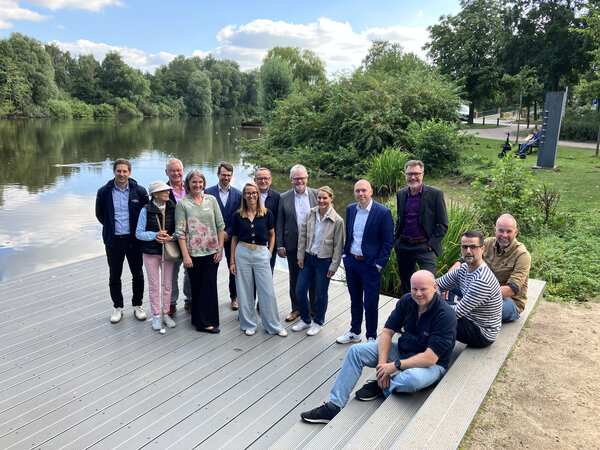 Bild vergr&ouml;&szlig;ern: Eine Personengruppe um Elmshorns Oberb&uuml;rgermeister Erik Sachse und Baustadtrat Marius Munk auf einer Terrasse am See des Steindammparks in Elmshorn.