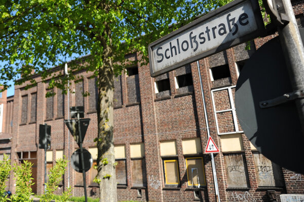 Bild vergr&ouml;&szlig;ern: Stra&szlig;enschlid der Schlo&szlig;stra&szlig;e im Vordergrund. Im Hintergrund die rot geklinkerte Fassade des ehemaligen Cita Strom-Geb&auml;udes an der Schlo&szlig;sstra&szlig;e / Ecke Berliner Stra&szlig;e