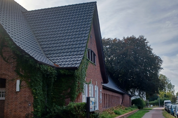 Ansicht eines Kirchengeb&auml;udes an einem Fu&szlig;g&auml;ngerweg.
