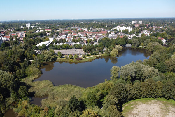 Bild vergr&ouml;&szlig;ern: Blick aus der Vogelperspektive auf einen See mit gr&uuml;nen B&auml;umen darum herum.