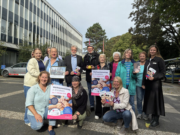 Bild vergr&ouml;&szlig;ern: Zahlreiche Frauen und M&auml;nnder vor dem Elmshorner Rathaus, die mit Plakaten und Flyern Werbung f&uuml;r den Weltseniorentag am 1. Oktober machen.