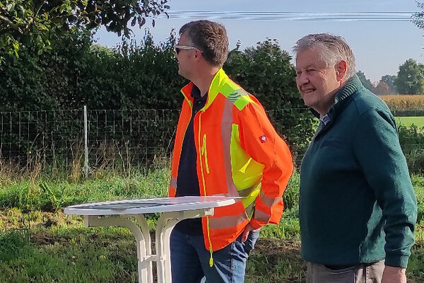 Bild vergr&ouml;&szlig;ern: Zwei m&auml;nnliche Personen an einem Stehtisch auf einer Wiese