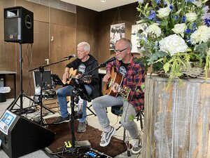 Bild vergr&ouml;&szlig;ern: Zwei M&auml;nner mit Gitarre sitzen auf St&uuml;hlen vor Mikrofonen und machen Musik.