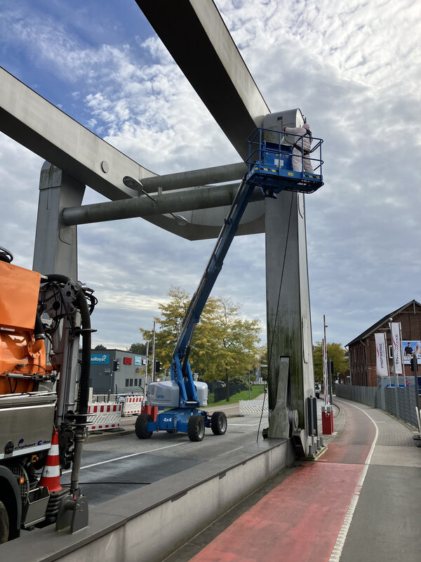 Bild vergr&ouml;&szlig;ern: An dem Br&uuml;ckenkopf der Br&uuml;cke steht ein blauer Hubsteiger.