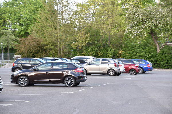 Mehrere parkende Autos auf einer größeren Parkfläche.