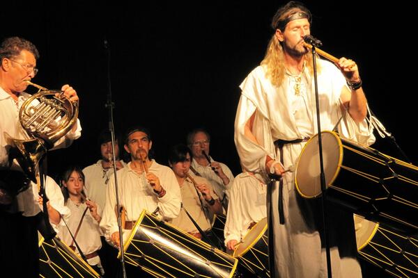 Bild vergr&ouml;&szlig;ern: Eine Gruppe in Kost&uuml;men keltischer Musikanten mit Trommeln und Blasinstrumenten musizieren.