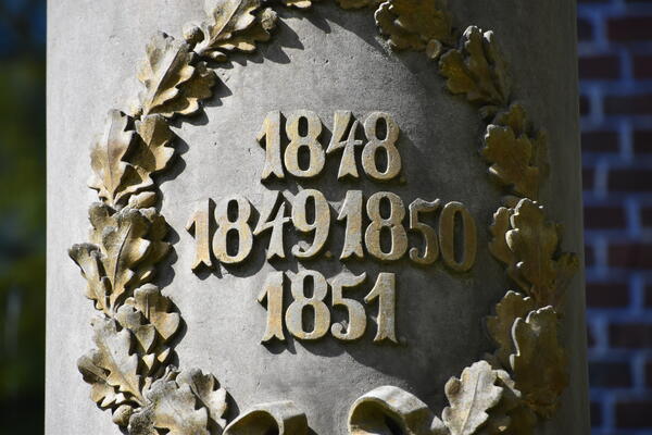 Bild vergr&ouml;&szlig;ern: Die Gedenks&auml;ule erinnert an die Opfer der Schleswig-Holsteinischen Erhebung von 1848 bis 1851. Es gibt zwei Tafeln mit den 16 Namen.