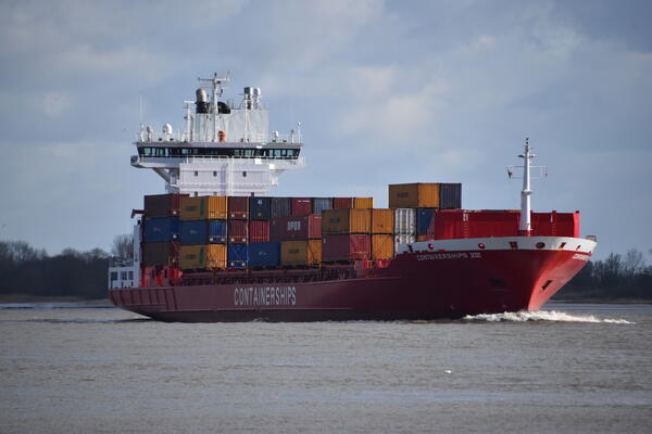 Das Schiff auf der Elbe hat viele, bunte Container geladen.