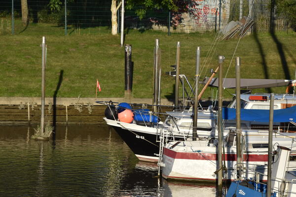 Segelboote und Motorboote liegen am Steg im Elmshorner Hafen.