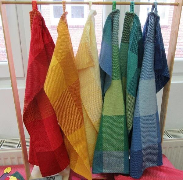 In der Weberei können selbstgewebte Stoffe hergestellt und genäht werden. Farbenfrohe Handtücher werden angeboten.
