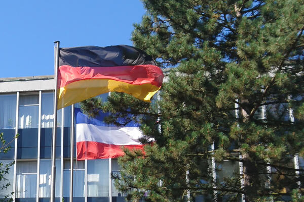 Wehende Flaggen vollmast vor dem Elmshorner Rathaus. Zu sehen sind die Bundesflagge und die Landesflagge Schleswig-Holstein.