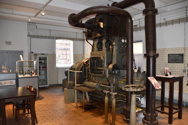 Eine alte, imposante Dampfmaschine, die bis an die Decke des Ausstellungsraumes reicht.