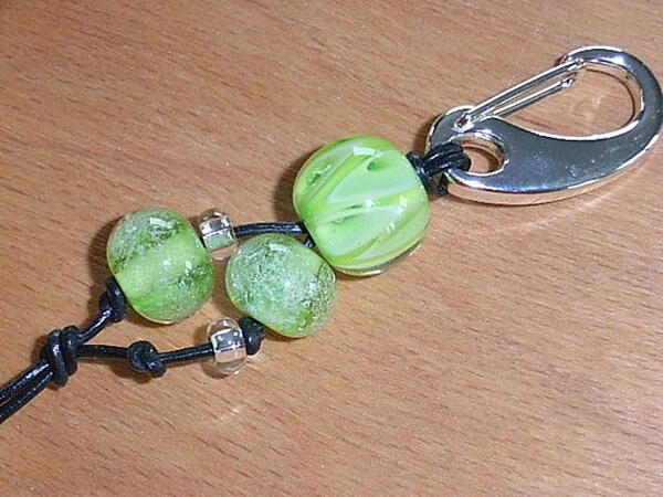 Ein Schlüsselanhänger mit grünen Glassteinen.